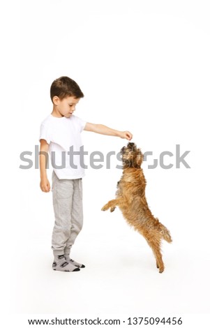 little boy is training the dog on white background 