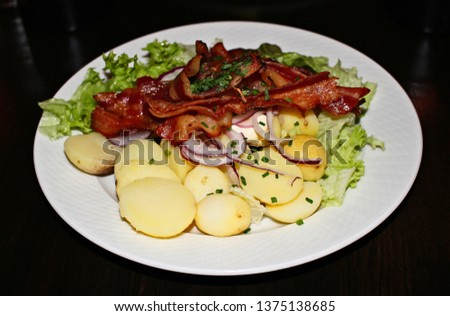 Fried bacon strips and small potatoes. This is a typical lunch dish found in Copenhagen, Denmark.  
