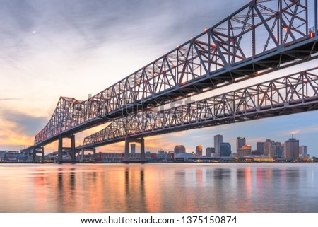 New Orleans, Louisiana, USA at Crescent City Connection Bridge over the Mississippi River at dusk.