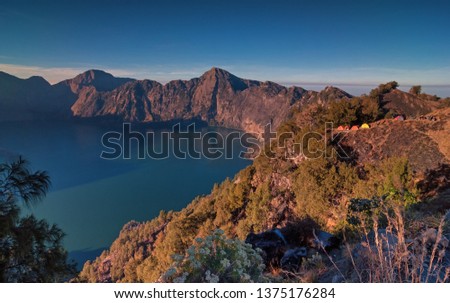Amazing crater, beautiful Anak Rinjani and lake view of Mount Rinjani from Senaru rim. Mount Rinjani is an active volcano in Lombok, Indonesia. Motion blurry and soft focus due to long exposure shot.