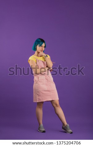 arrogant unhappy woman with modern hairdo with offensive expression looking aside isolated on blue background.