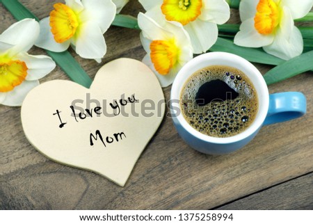 I love you mom. Greeting card for mother's day. Cup of coffee and spring flowers on a wooden table