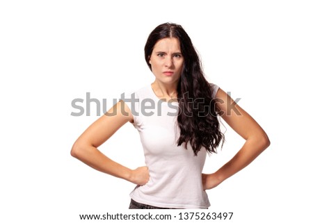 Angry girl standing with hands on waist and looking at camera