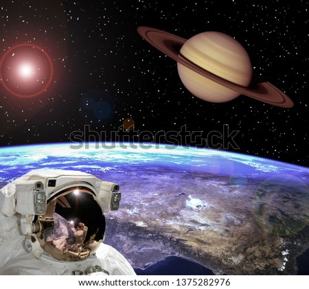 Astronaut staring at the saturn. Scene above earth. The elements of this image furnished by NASA.
