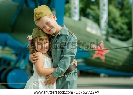 happy kids a boy of 6 years and a girl of 4 years of European appearance in a military suit, soldier, May 9, 1941-1945, victory, in Russia the Great Patriotic War Royalty-Free Stock Photo #1375292249
