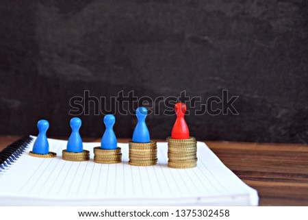 On a wooden background coins were stacked, which together form an ascending curve, on each of the heaps is a character. The figure with the highest value has a different color
