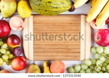 different fresh juicy fruits scattered on a light wooden background. space for text
