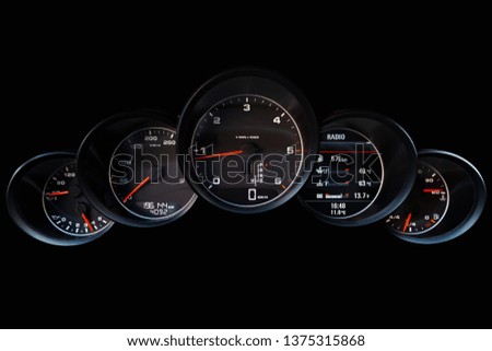 The dashboard of the car is glowing white and red with a speedometer, tachometer, oil temperature, tank volume and other tools to monitor the condition of the vehicle
