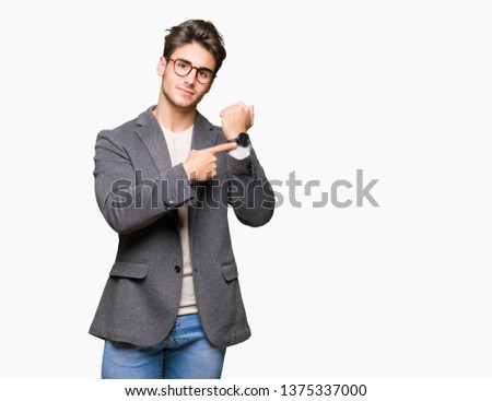 Young business man wearing glasses over isolated background In hurry pointing to watch time, impatience, upset and angry for deadline delay