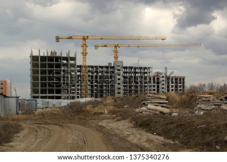 Unfinished construction with cranes view from far. Building concept image