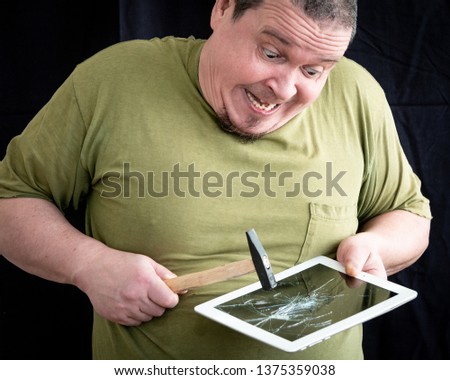 funny, nervous man smashes a laptop with a hammer
