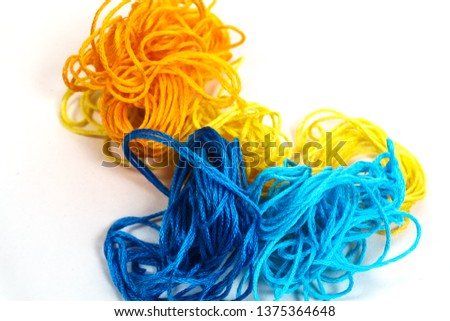 background of yellow orange blue and blue threads on white