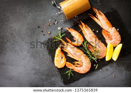 Seafood. Raw shrimps with spice and lemon on a slate board. Top view flat lay background. Free space for your text.