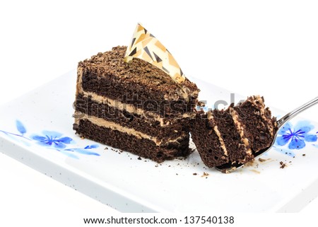 Chocolate cake piece on plate with spoon isolated on white background