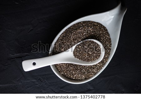 Organic chia seeds on dark wooden table with copyspace