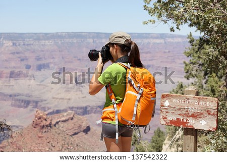 Hiking photographer taking pictures in Grand Canyon at hike by south rim by Bright Angle trail. Young woman hiker enjoying nature landscape in Grand Canyon, Arizona, USA.