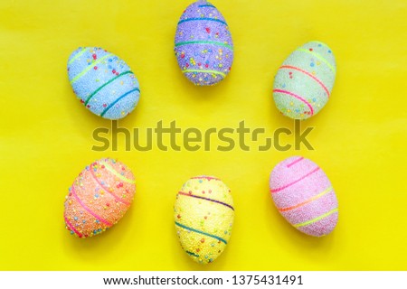 Handmade Easter eggs on a yellow background. Space for text.