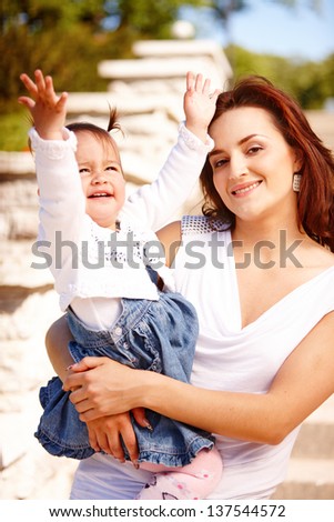 Young mother with child outside on a summer day