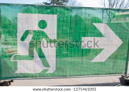 the sign of running man with arrow, green color exit an emergency sign 
