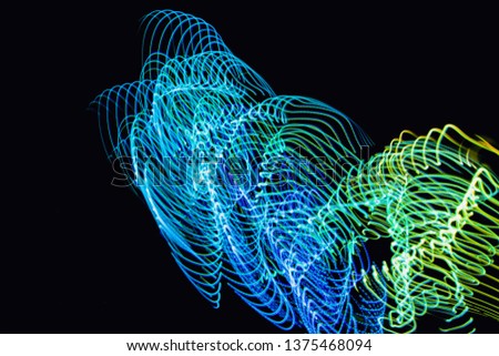 Abstract neon lights trails in the black background. Futuristic overlay light pattern.