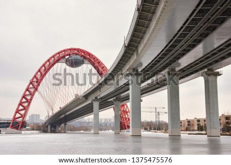 bottom view of the road bridge with a red arch, the picturesque bridge across the Moscow River, the picturesque bridge with a flying saucer Royalty-Free Stock Photo #1375475576