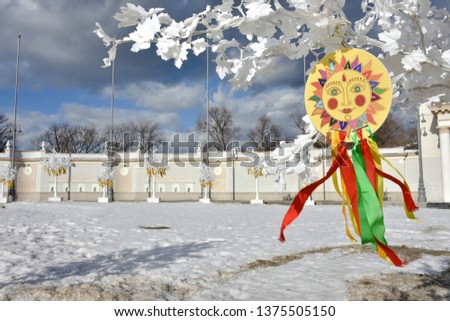 emblem of sun with colorful ribbons on branches of white tree,the symbol of carnival on white tree in the park,sun picture,Shrovetide in park,images of the sun with ribbons at Shrovetidel,Pancake week