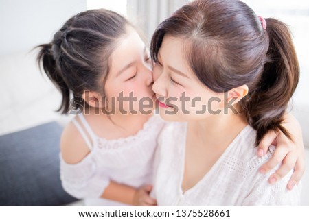 Daughter kiss her mom tenderly and mom smile happily