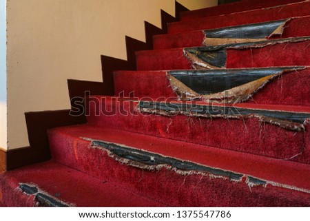 Stairs inside the building was made by the skin red carpet. The condition of the carpet is old and torn.