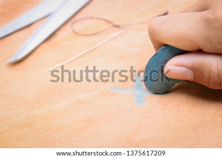 Sewer using signing chalk for making sign in sewing work. people daily life activity concept  