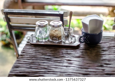 Blurred background of decorative items in restaurants, coffee, bakery, home and garden decoration (glass, vase, wood counter, wooden chair) for customers to take pictures and stop during travel. Royalty-Free Stock Photo #1375637327