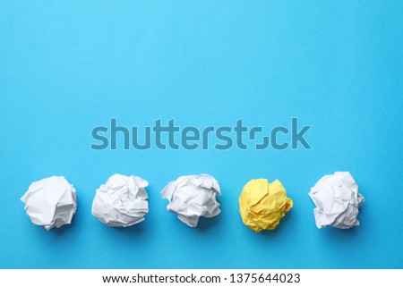 Yellow sheet of crumpled paper among white ones on color background, flat lay. Space for text