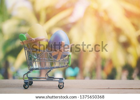 close up toy shopping with easter eggs on wood table, nature copy space background for text, hello spring season concept