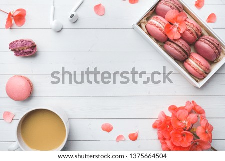 Cup of coffee, macaroon cookies in a box, flowers on a white background. copy space. concept beautiful Breakfast. flat lay.