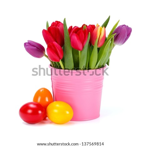 Colorful tulips in pink bucket and three painted Easter eggs