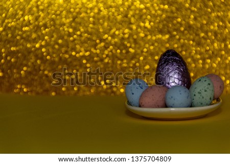 Violet egg on a golden background, surrounded of colorful eggs