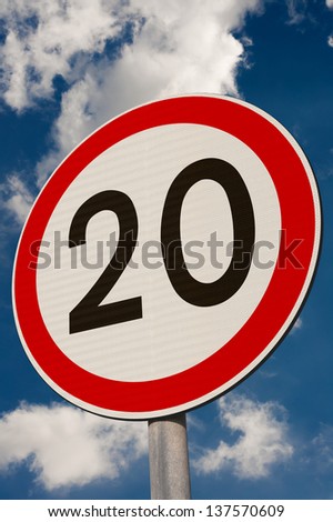 Speed limit sign against a blue sky.