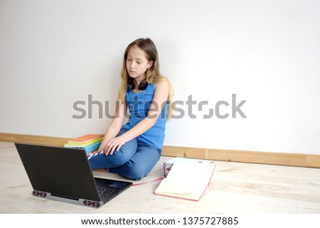 Teenage girl uses a laptop. Online education, home schooling. Communication on the Internet, chats. Distance learning