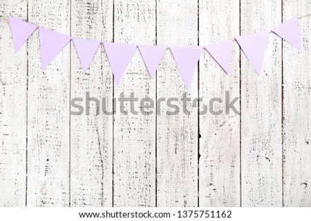 Paper flags hanging on white wooden background