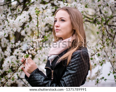 The girl is about to blossom a tree in the spring