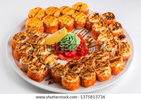 Hot delicious set of baked sushi rolls. For the menu, on a plate, white background.