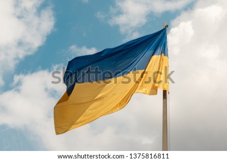 clsoe-up of national flag of Ukraine on a flagpole against the sky with white clouds. The symbol of presidential ballot and poll in Ukraine 2019