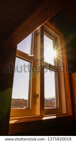 Sun rays shining into a window of a cabin on the Arctic Circle Trail in Greenland.