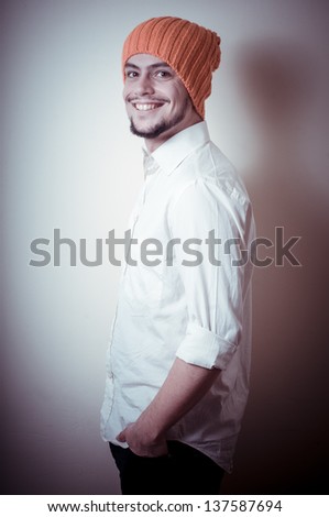 young modern stylish man with orange cap on vignetting background
