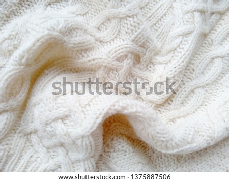 Knitted clothes from wool yarn. Background of wool yarn for yarn frame. White knitting yarn for handicrafts background.