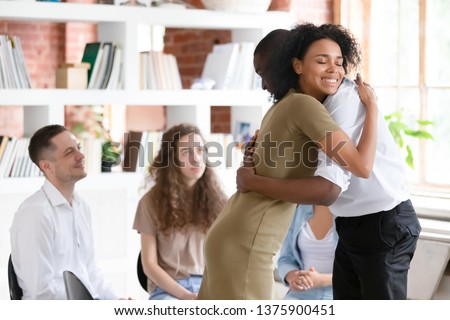 Biracial woman psychologist addiction counsellor hug afro guy at group session express support gratitude for honesty, diverse people gather together solve problems abuse struggle, rehab center concept Royalty-Free Stock Photo #1375900451