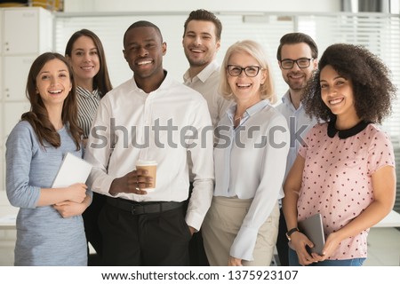 Motivated international multi-ethnic company members aged and young corporate team photographing posing for camera, successful staff portrait concept of growth in career leadership and racial equality Royalty-Free Stock Photo #1375923107