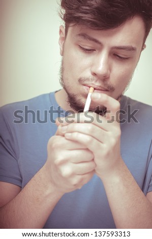 stylish young modern man with cigarette on vignetting background