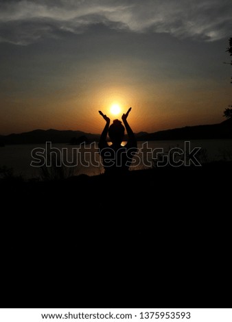 
Silhouettes of a man and a woman  to catch the sunrise at evening.