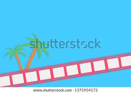 Palm trees and film strip cut out of colored paper on blue table. Top view. Travel concept. Copy space