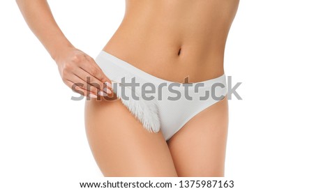 woman touching with feather her genitals wearing panties , showing smooth skin after epilated or depilating bikini area. Royalty-Free Stock Photo #1375987163